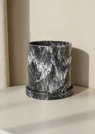 Maceta cilíndrica de diseño con efecto mármol negro y blanco, ideal para decoración contemporánea de interiores